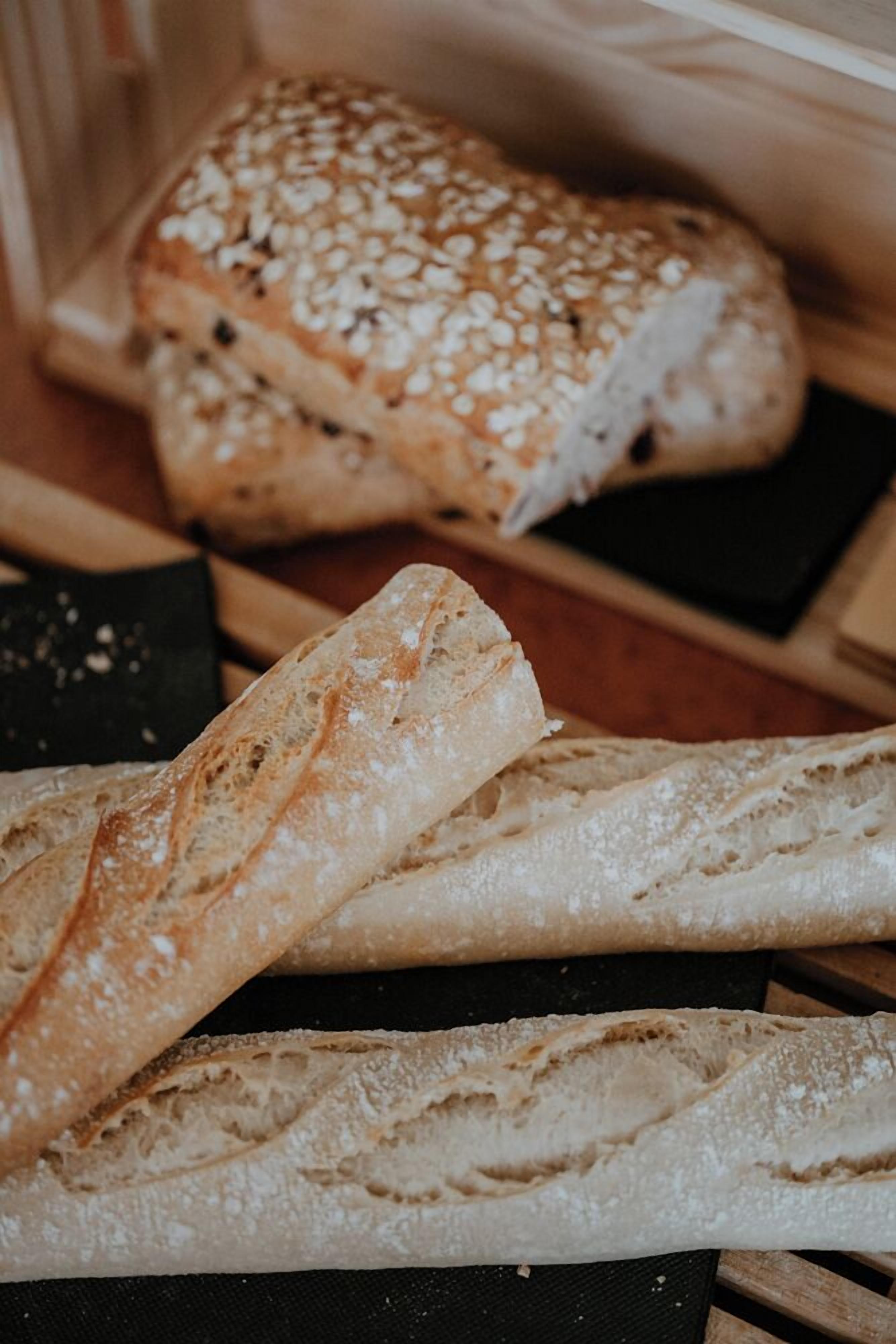Een brood met sesamzaadjes en een stokbrood.