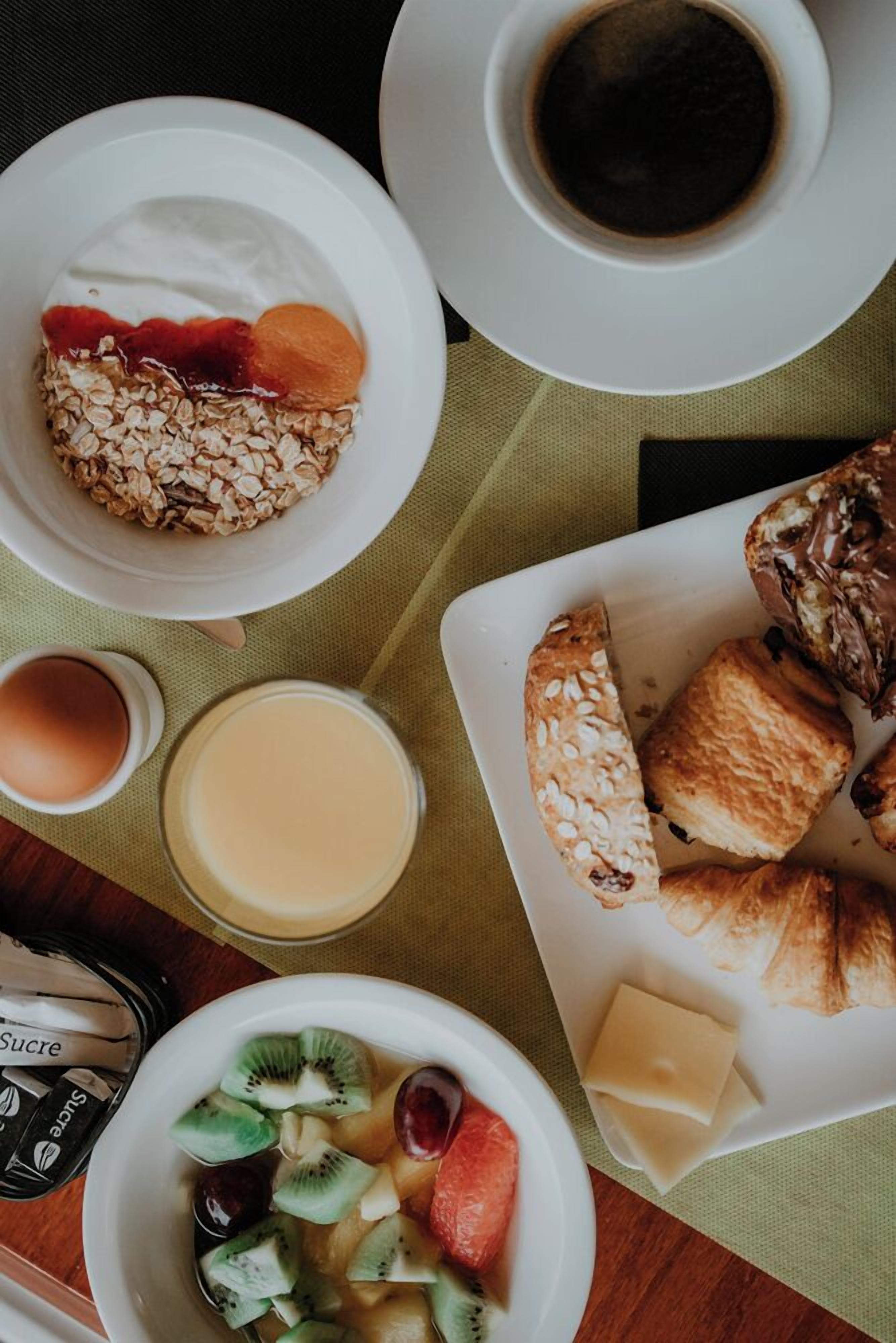 Une table dressée pour le petit-déjeuner, avec divers aliments et boissons.