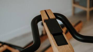 Ein stationäres Fitnessrad mit Holzrahmen und schwarzen Lenkern.