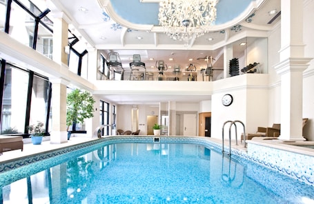 Indoor pool, pool loungers. Queen's Court Hotel & Residence