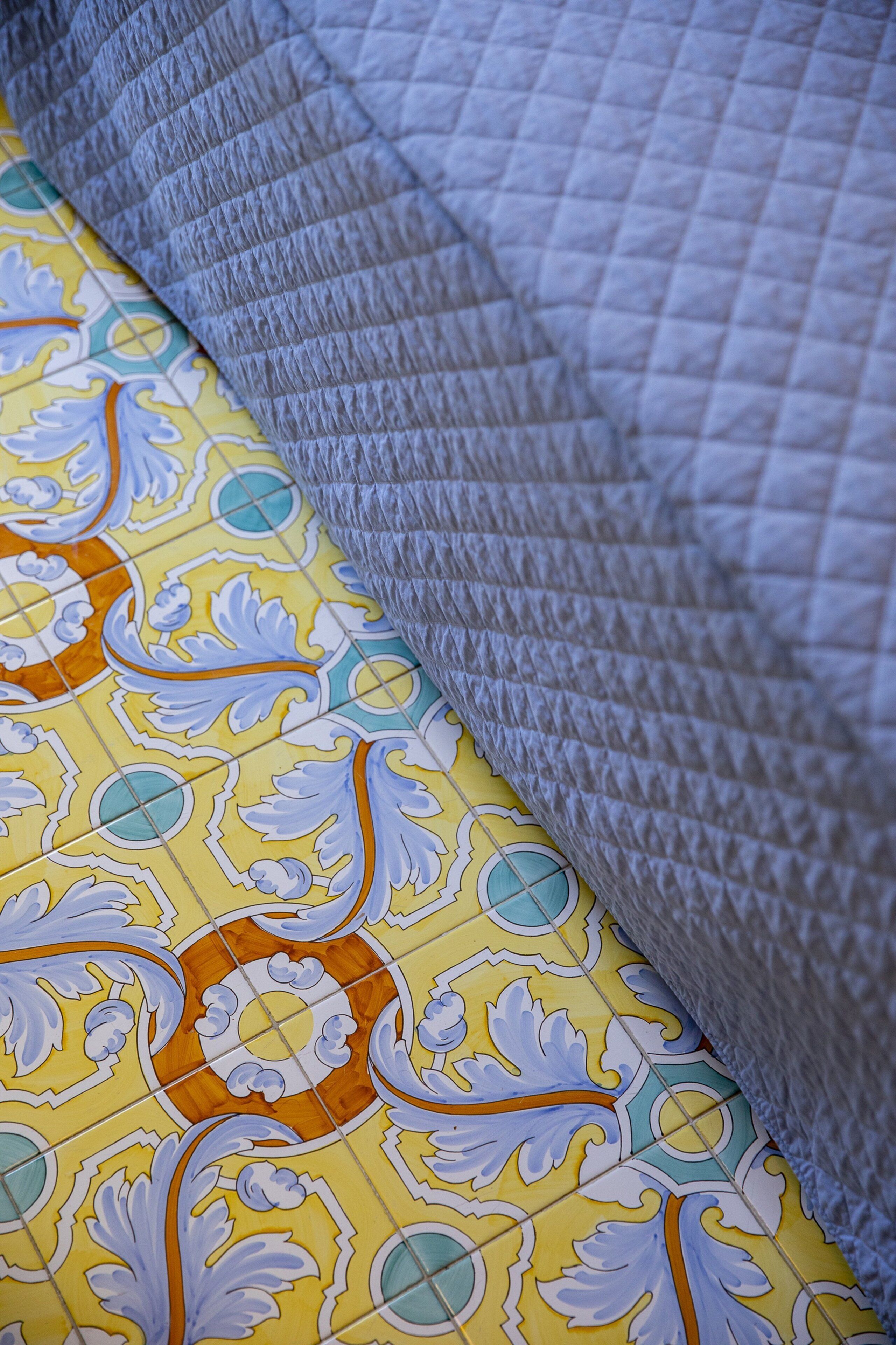 Un gros plan d’un tissu à motifs, avec un dessin géométrique et un tissu matelassé texturé.