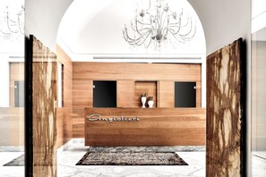 A reception desk with a wooden finish and the name "Angiolieri" on it. - Grand Hotel Angiolieri (Vico Equense)