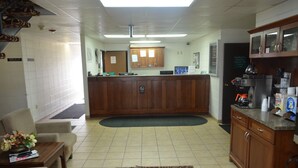 A lobby with a reception desk, seating area, and a kitchenette. - Grand Inn Fargo (Fargo)