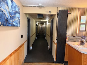 A hotel hallway with a marble wall art, a reception desk, and a check-in counter.