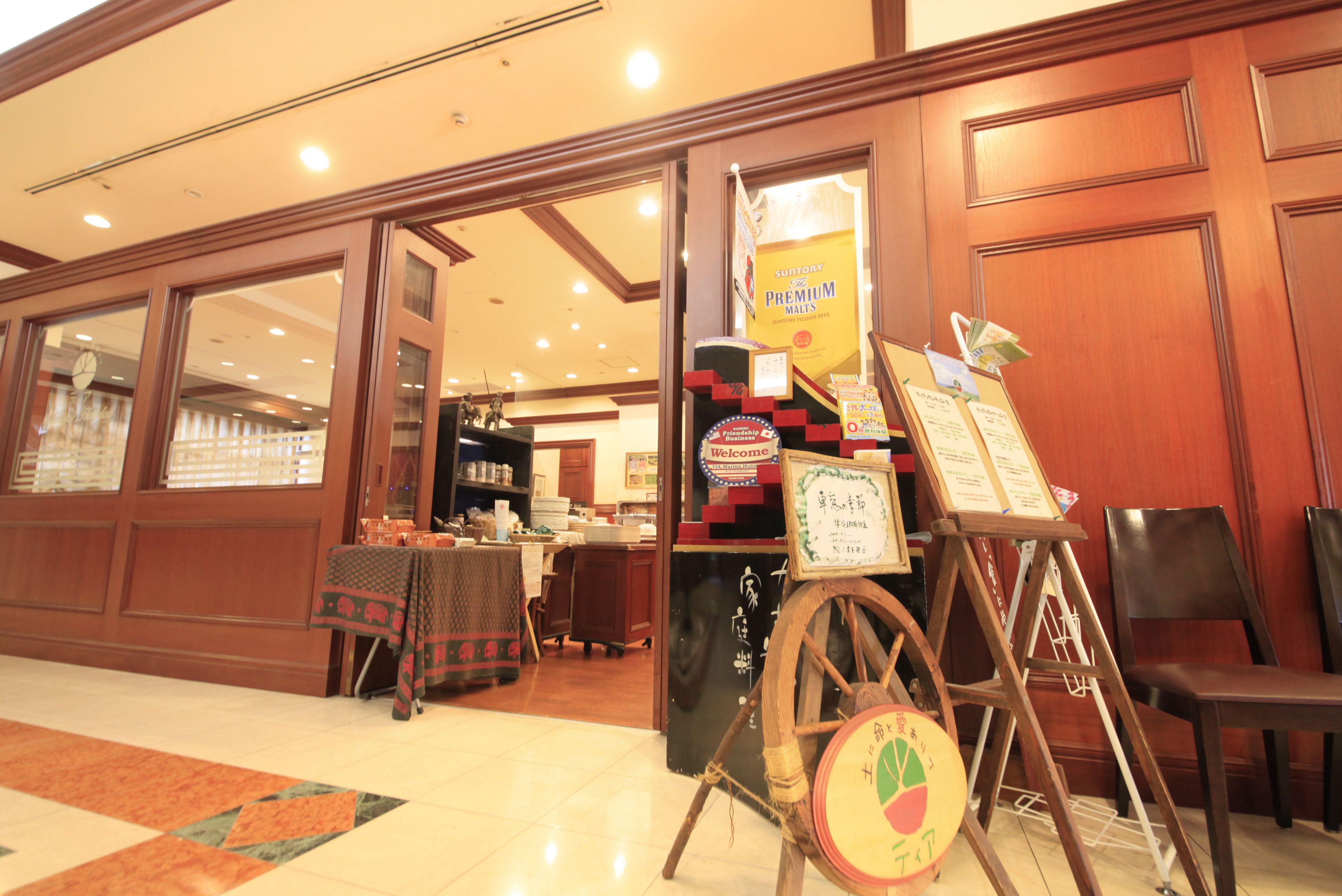 A hotel lobby with a reception desk, a wooden chair, and a signboard.