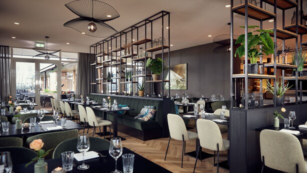Ein modernes Restaurant mit verschiedenen Essbereichen, schwarzen Tischen und Stühlen. Regale mit Pflanzen und Dekorationselementen sind ebenfalls vorhanden.