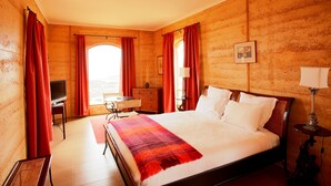 A hotel room with a large bed, a desk, a television, and a window with curtains. - Sky House Kangaroo Island (Middle River)