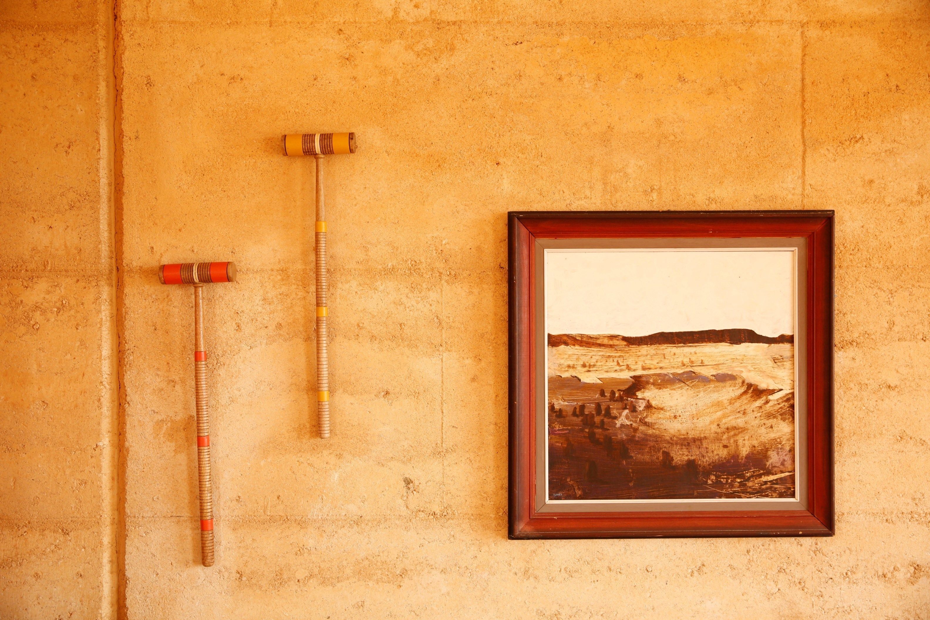 Un cuadro de paisaje enmarcadosobre una pared con textura.