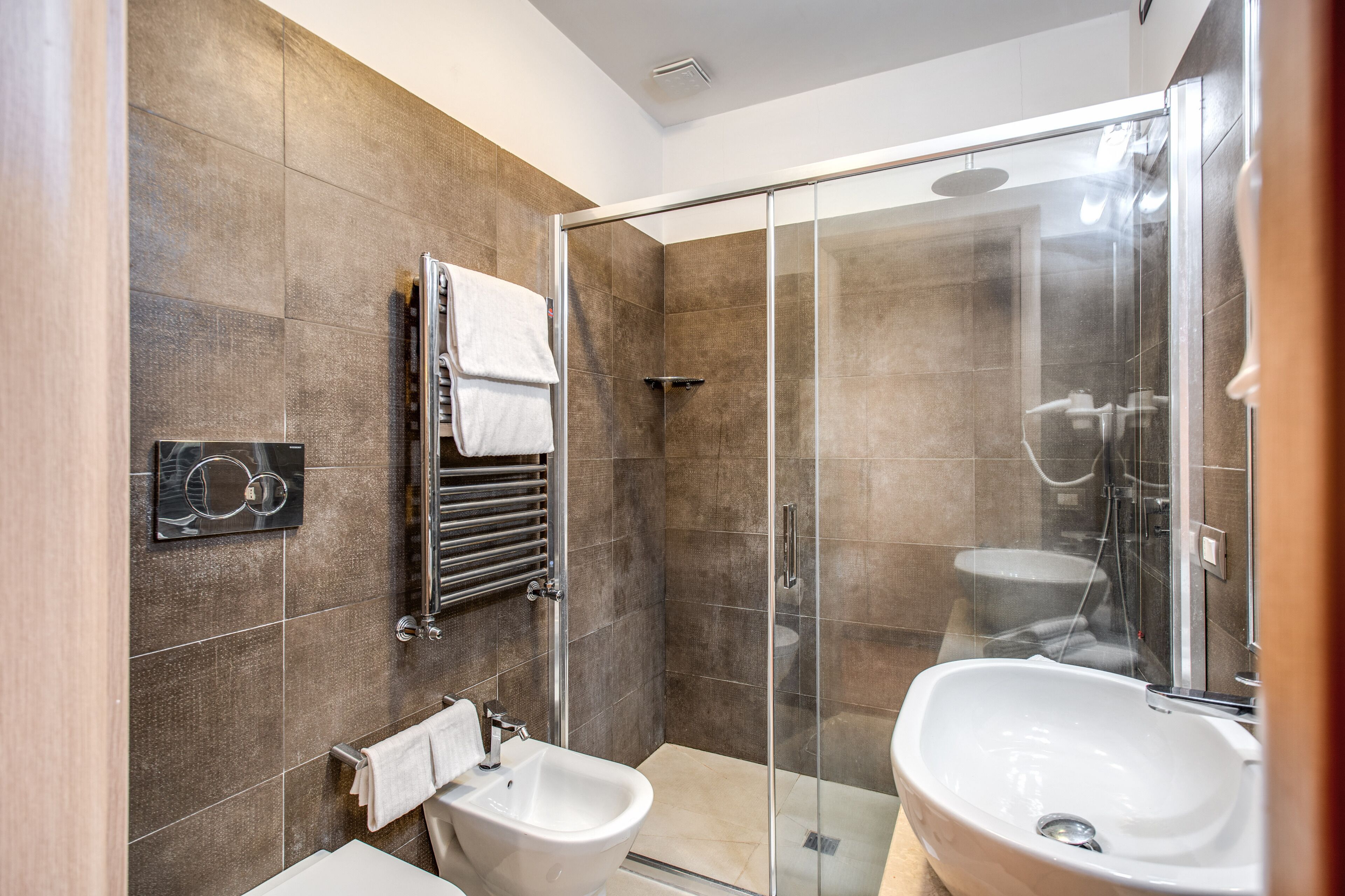 Ein modernes Badezimmer mit einer Duschkabine, einem Bidet und einem Waschbecken.