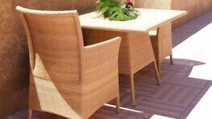 A terrace with wicker furniture and a table, overlooking a hilly landscape. - Villava Pamplona (Villava)