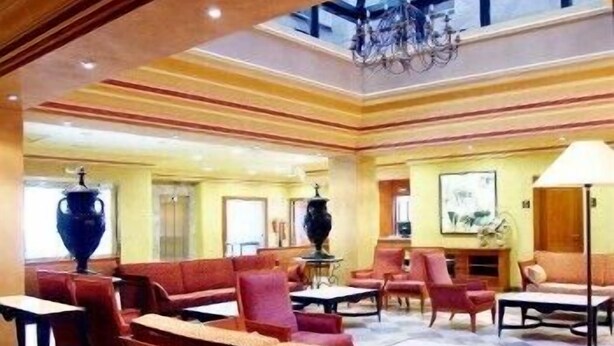 A spacious lobby with a high ceiling, large windows, and a chandelier. There are multiple seating areas with sofas and armchairs. - Villava Pamplona (Villava)