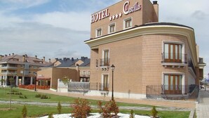 Um hotel com fachada curva e uma placa com a inscrição 'HOTEL Castilla'.