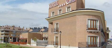 Ein Hotel mit einer gebogenen Fassade und einem Schild, auf dem "HOTEL Castilla" steht.