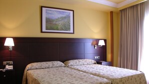 A hotel room with two beds, a painting on the wall, and two bedside lamps. - Dos Castillas (Ávila)