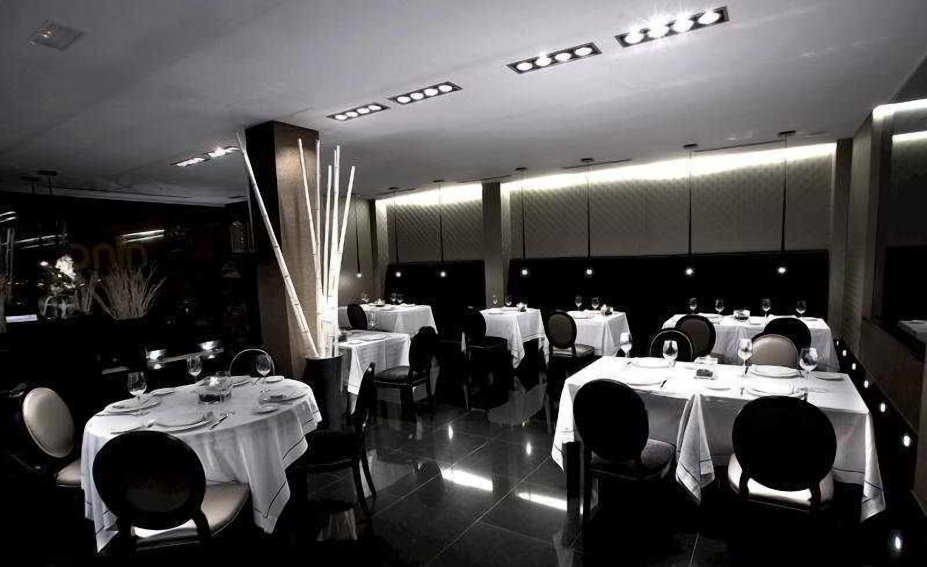 A restaurant with multiple tables, chairs, and a modern interior design.