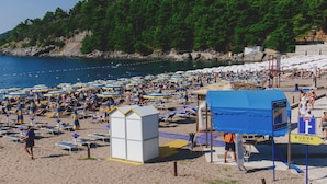 A crowded beach with numerous umbrellas and sun loungers. - Hotel Montenegro Beach Resort (Becici)
