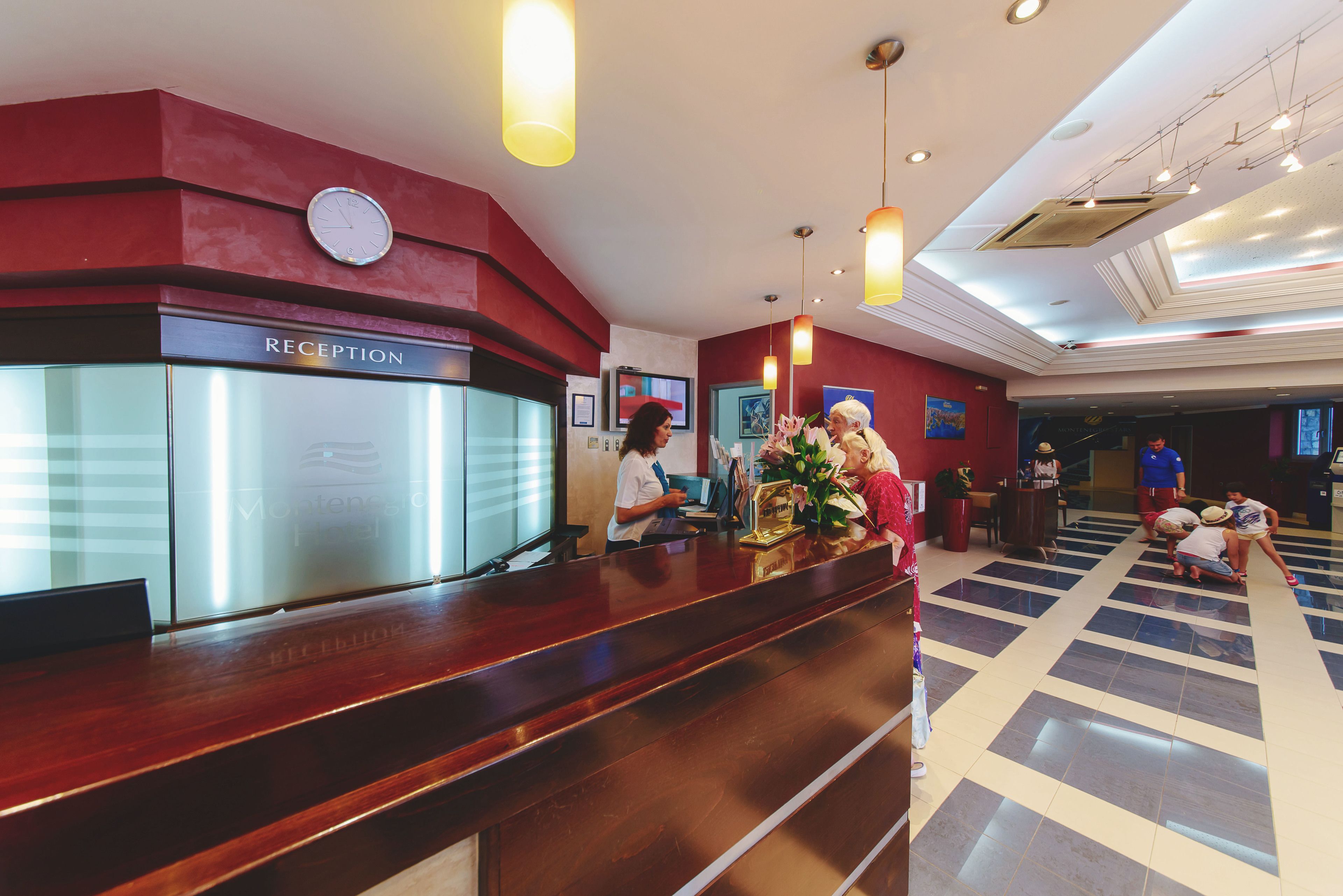 A reception area with a reception desk, a clock, and a check-in counter.
