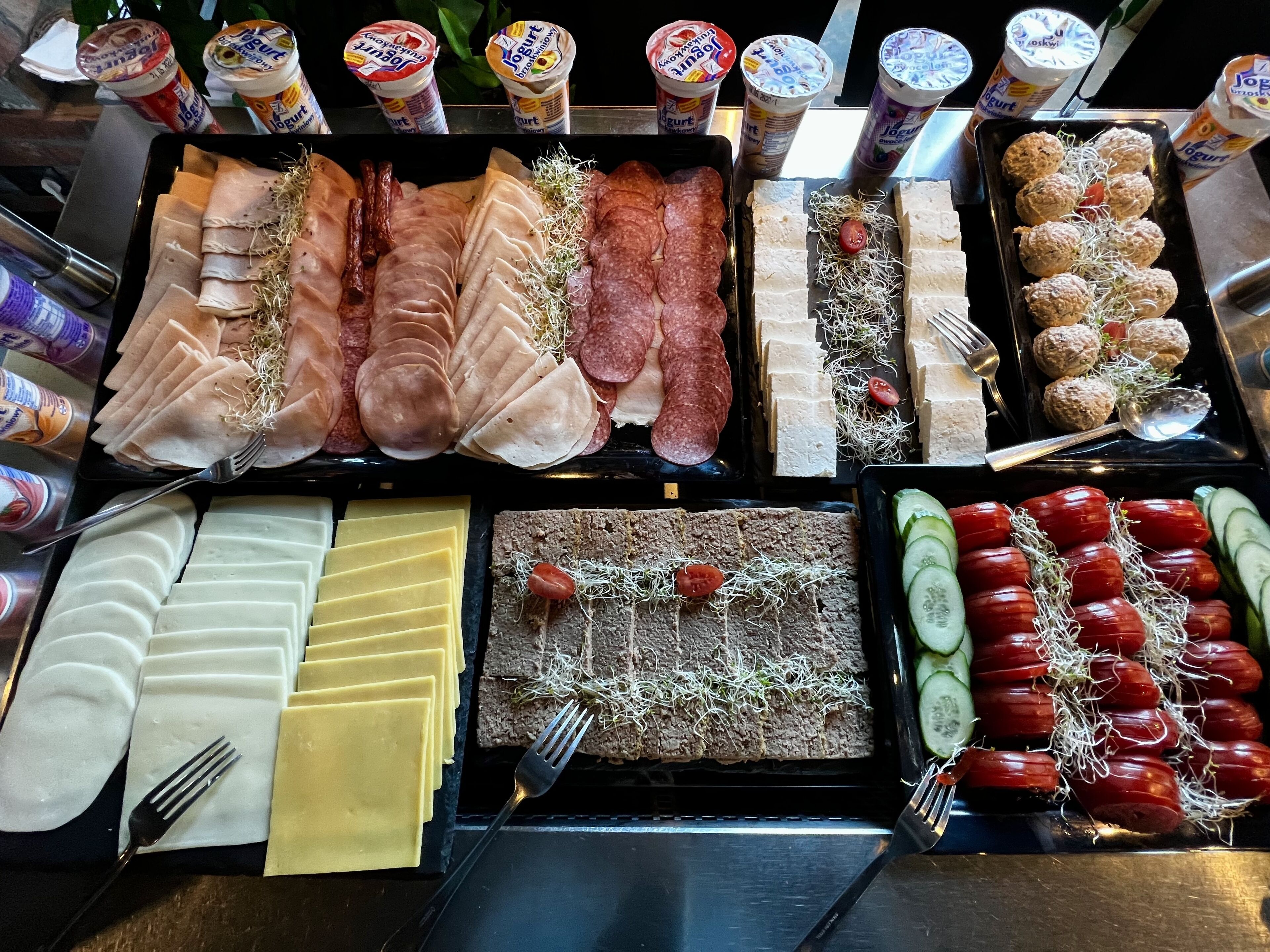 Un buffet proposant une variété de plats, notamment des viandes, des fromages et des légumes.