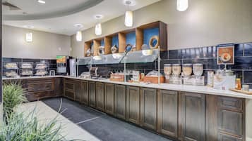A breakfast bar with various food items and a sign indicating a breakfast buffet.