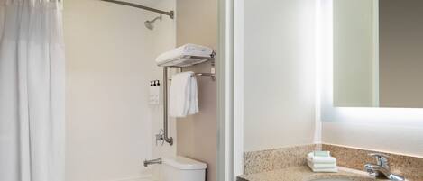 Une salle de bain avec douche, toilettes et lavabo.