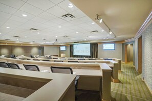 A conference room with a large screen displaying 'THE HELDRICH' and multiple rows of tables and chairs. - The Heldrich Hotel (New Brunswick)