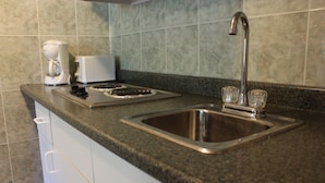 A kitchen with a stainless steel sink, a coffee maker, and a toaster on the countertop. - Tides Motor Inn at Stehli Beach (Locust Valley)