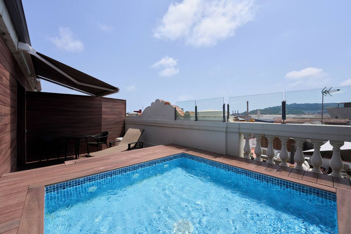 A rooftop swimming pool with a view of the cityscape.