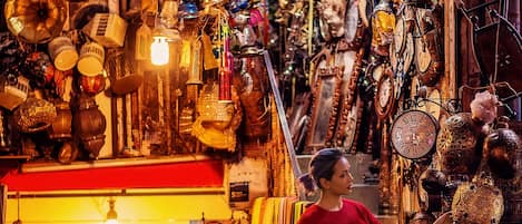 A narrow street with a variety of antique clocks and decorative items displayed on the walls and shelves.