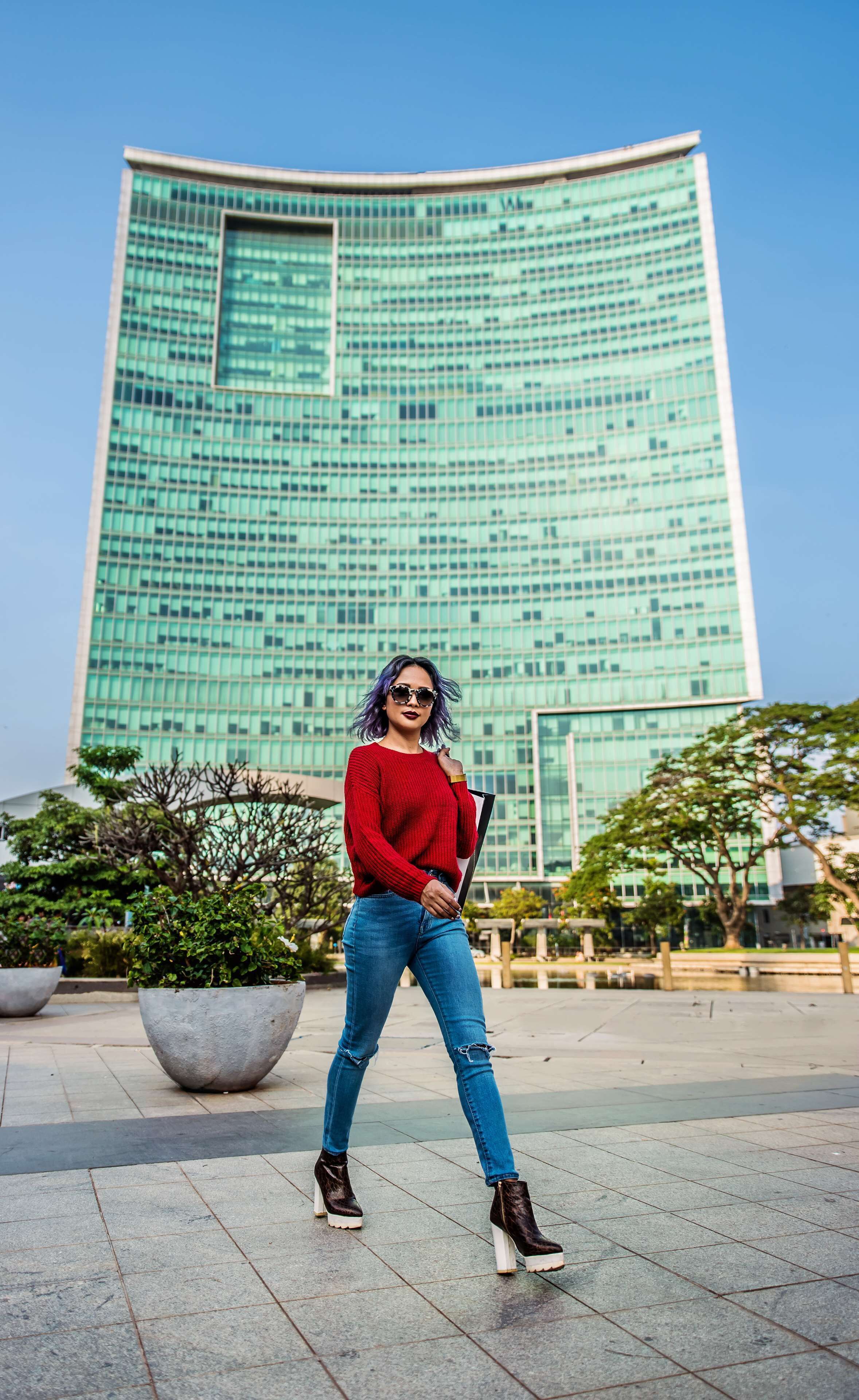 A person standing in front of a modern glass building.