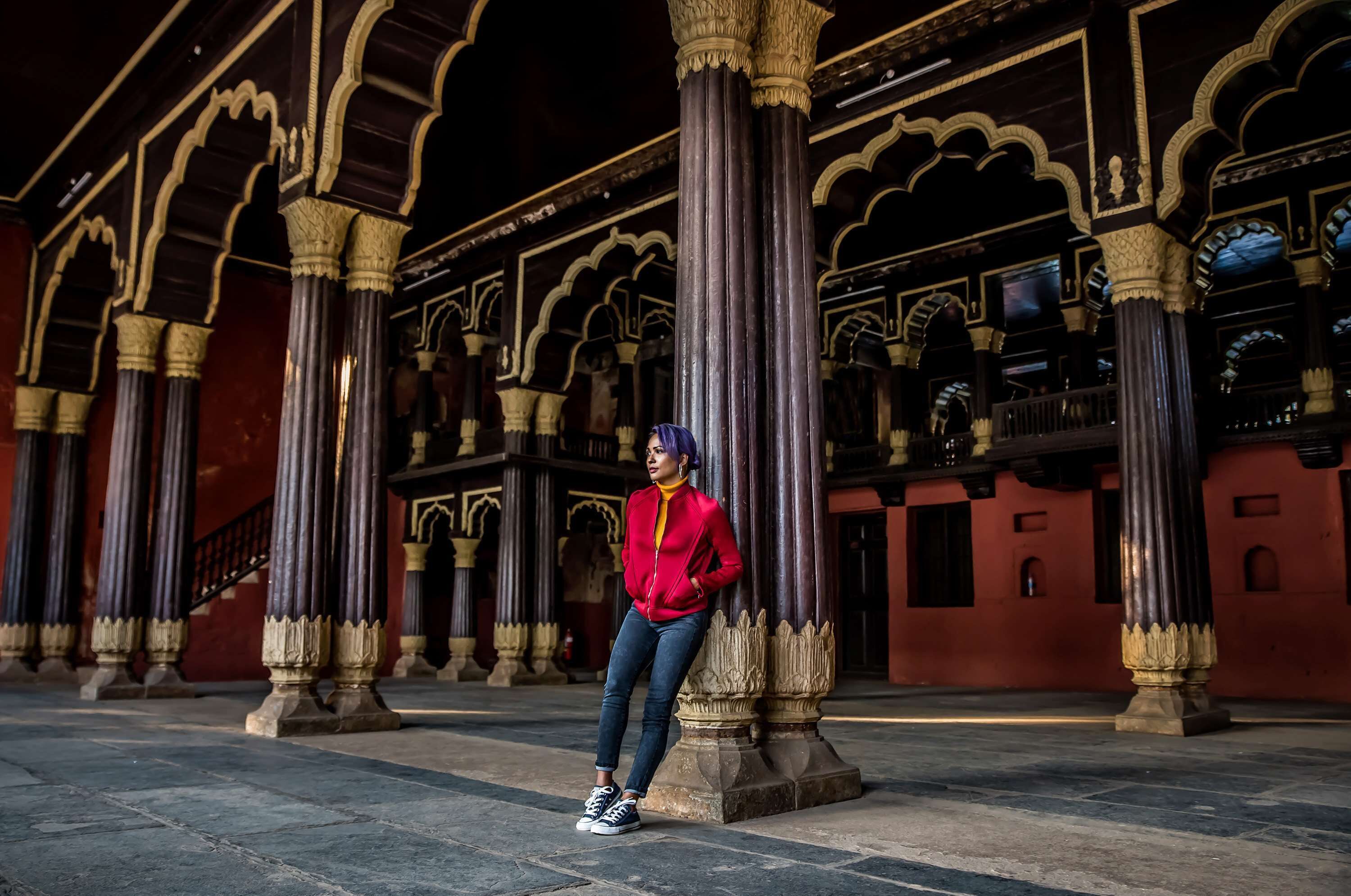 A person standing in an architectural space with ornate columns and arches.