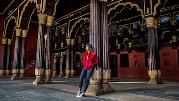 Una persona de pie en un espacio arquitectónico con columnas y arcos ornamentados.