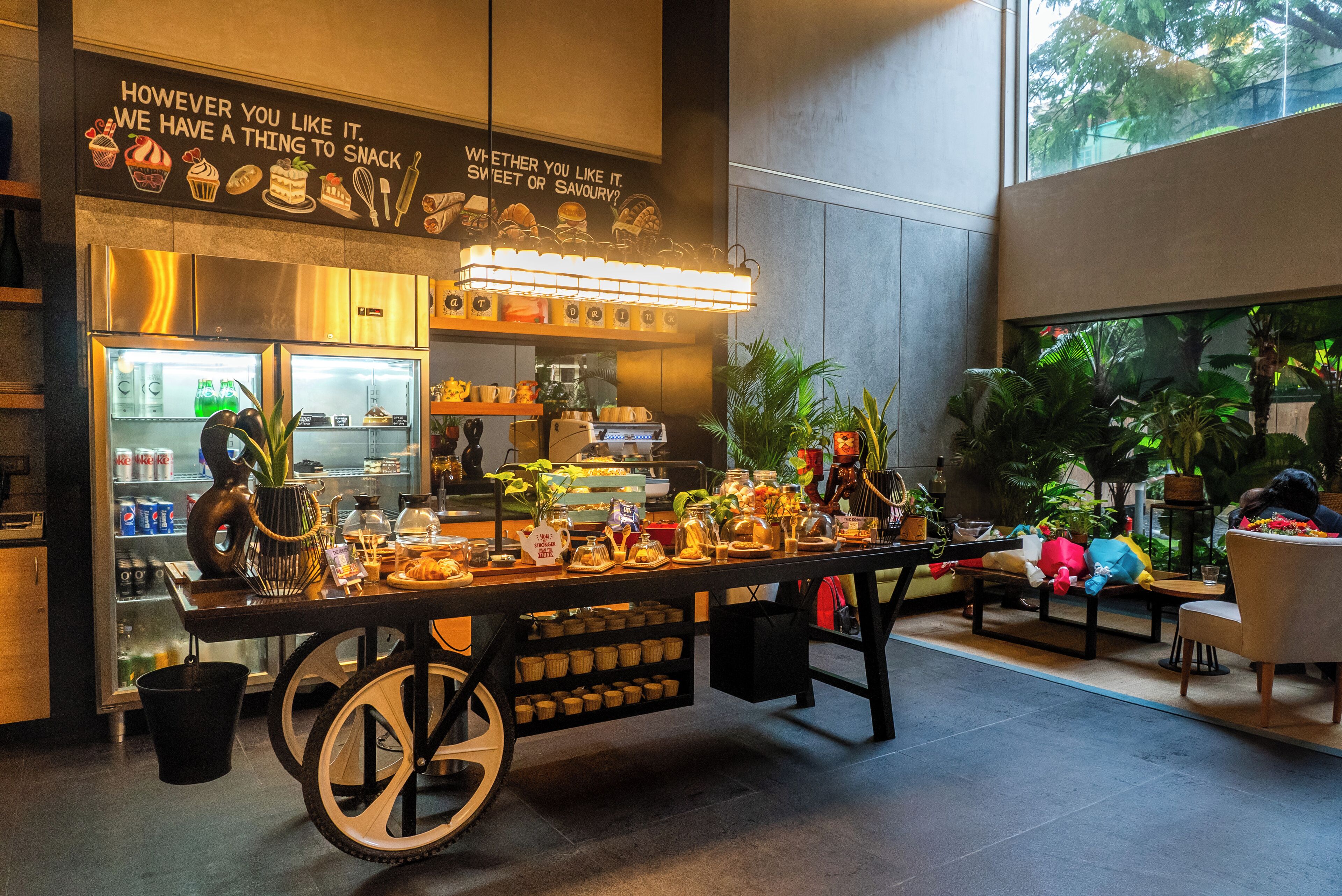 A food station with a variety of snacks and a refrigerated display.