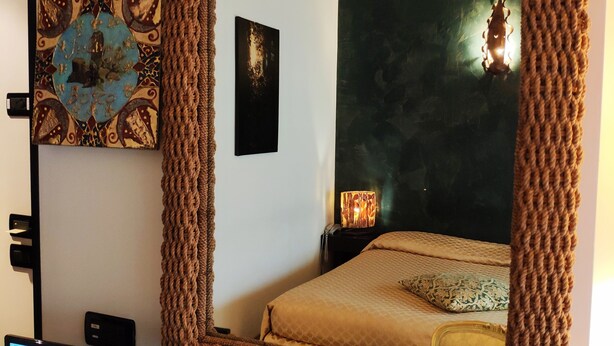 Ein Schlafzimmer mit einem großen Spiegel, einem Fernseher und Kunstwerken an der Wand.