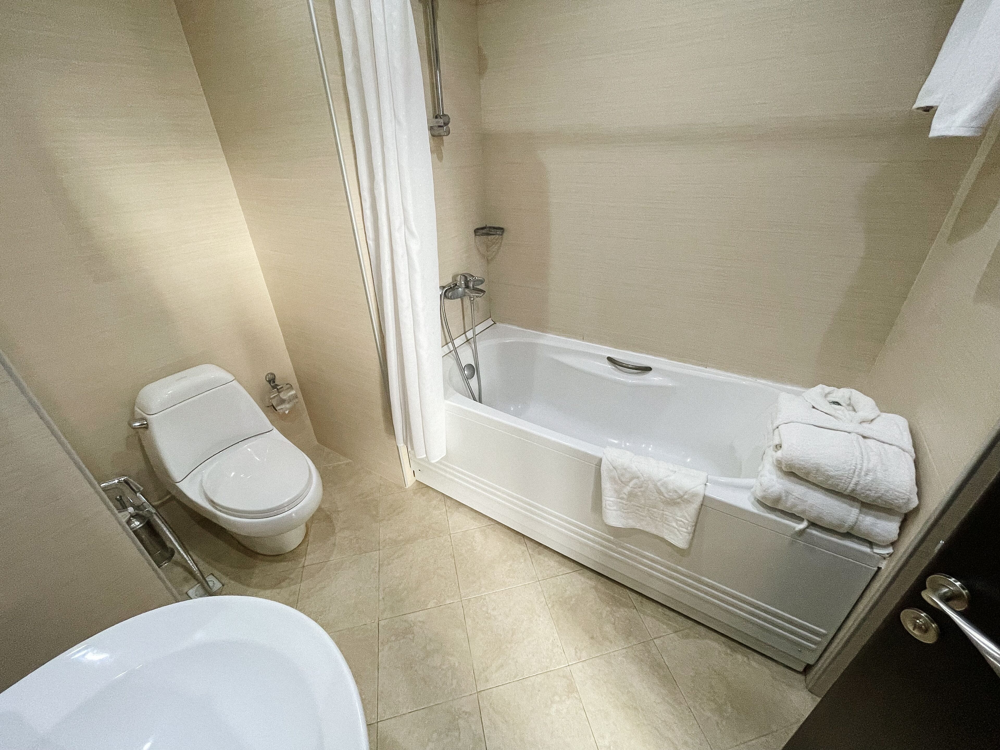 A bathroom with a toilet, a bathtub, and a sink.