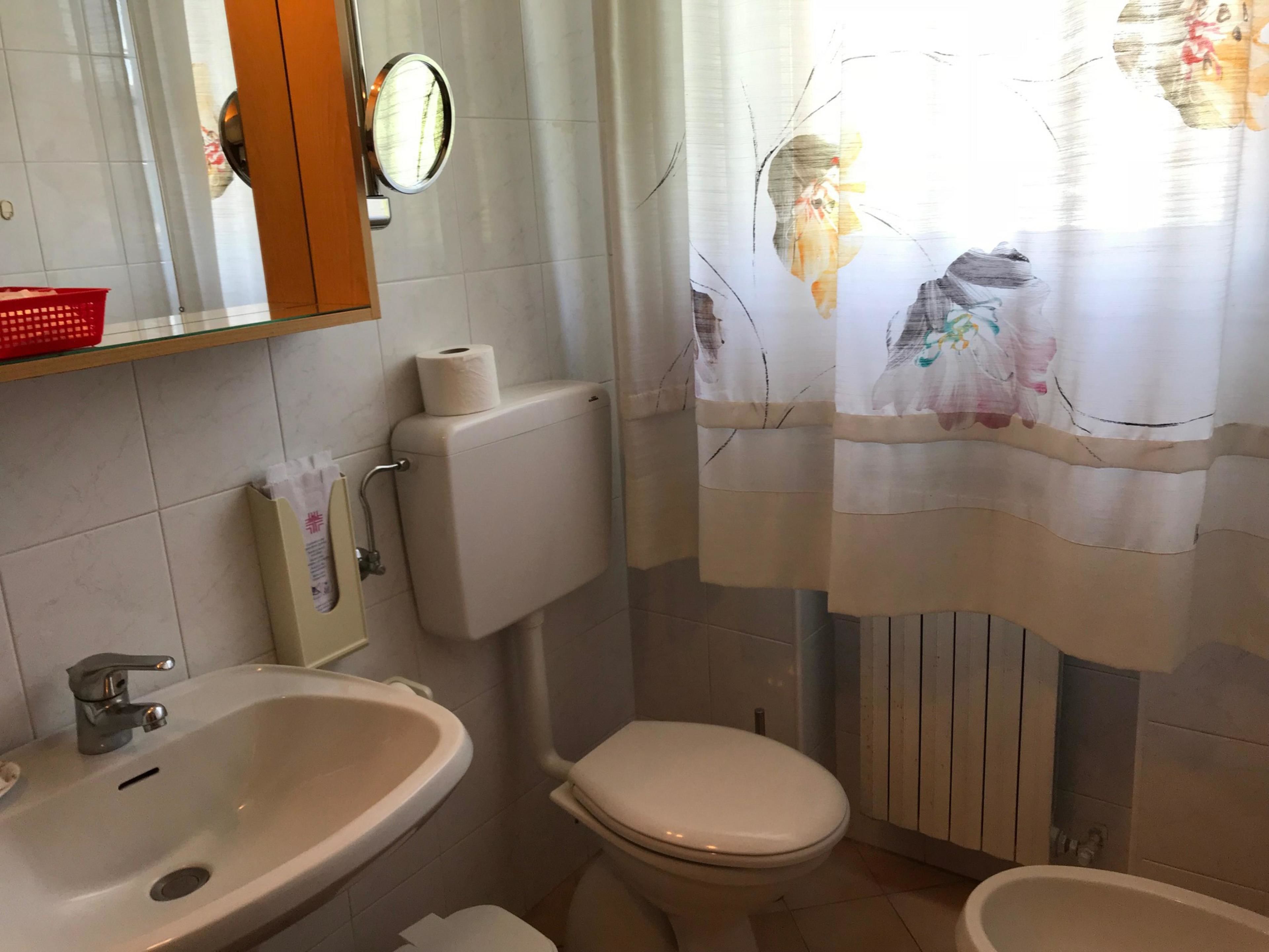 Une salle de bain équipée de toilettes, d’un bidet et d’un lavabo.