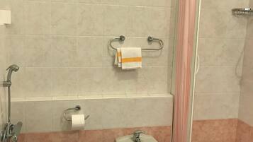 A bathroom with a toilet, bidet, and shower area.