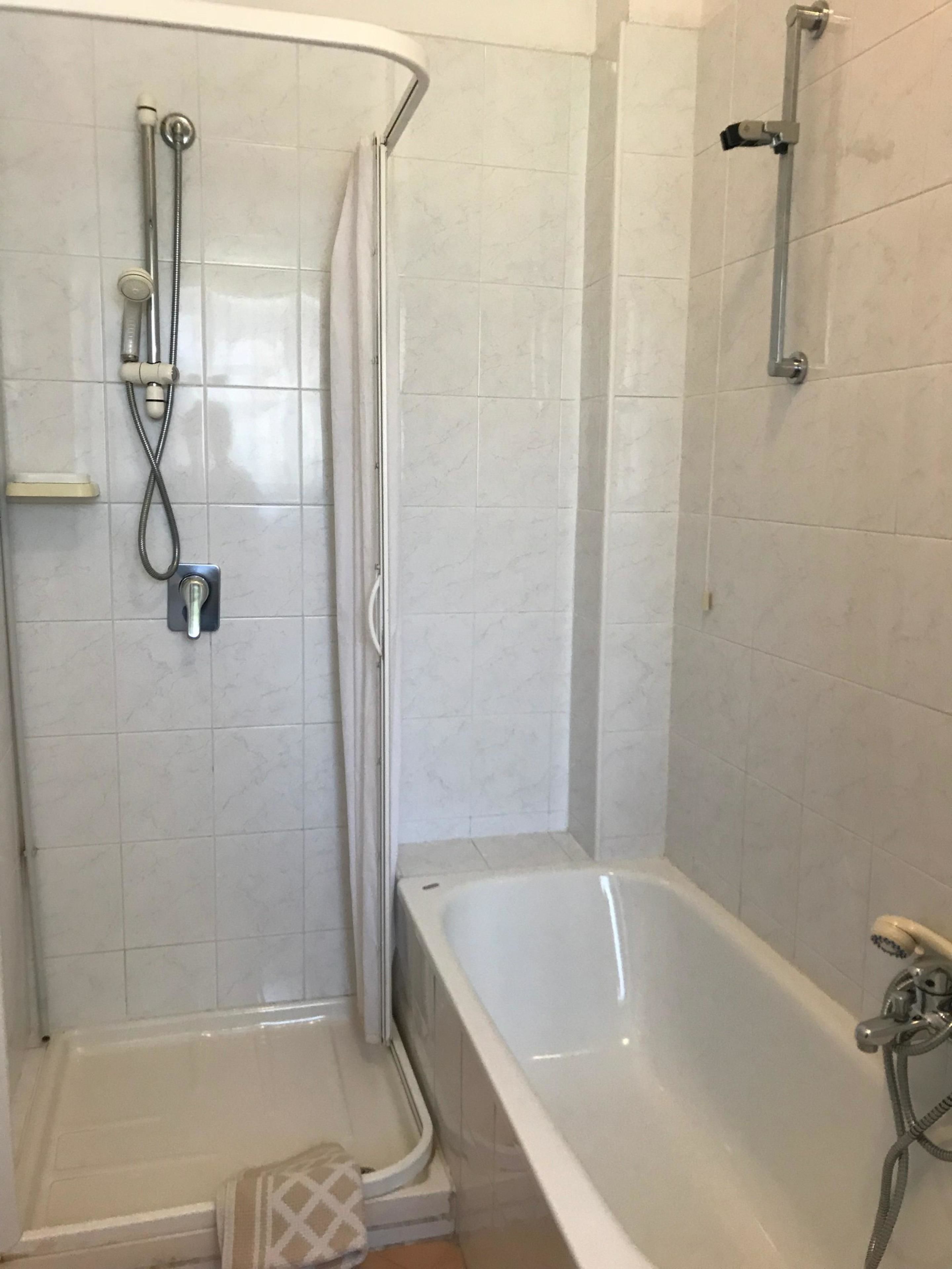 Un baño con ducha, bañera y retrete.