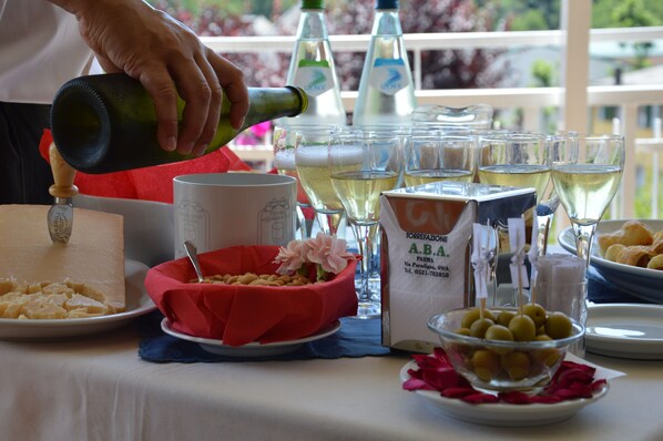 A table set with various food items, glasses of wine, and a bottle being poured.