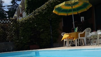 Een seizoensgebonden buitenzwembad, parasols voor strand/zwembad