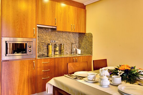 Una cocina bien equipada con armarios de madera, encimera de granito y electrodomésticos modernos.