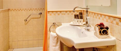 A bathroom with a bathtub, a sink, and a shower area.