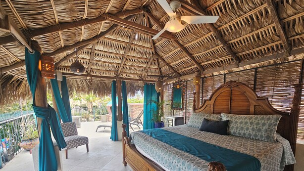 A room with a bed, a chair, and a ceiling fan. - Cabo Inn Hotel (Cabo San Lucas)
