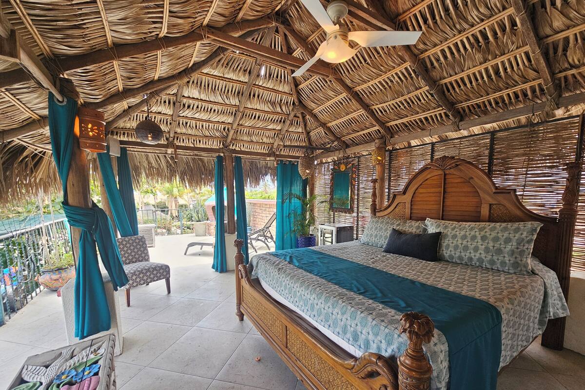 A room with a bed, a chair, and a ceiling fan.