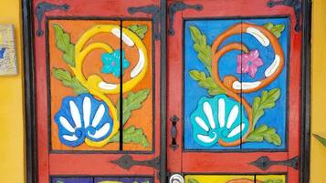 A colorful door with 'Welcome' written above it, featuring vibrant floral designs.