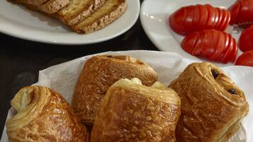 A table with various food items including croissants and sliced meats.