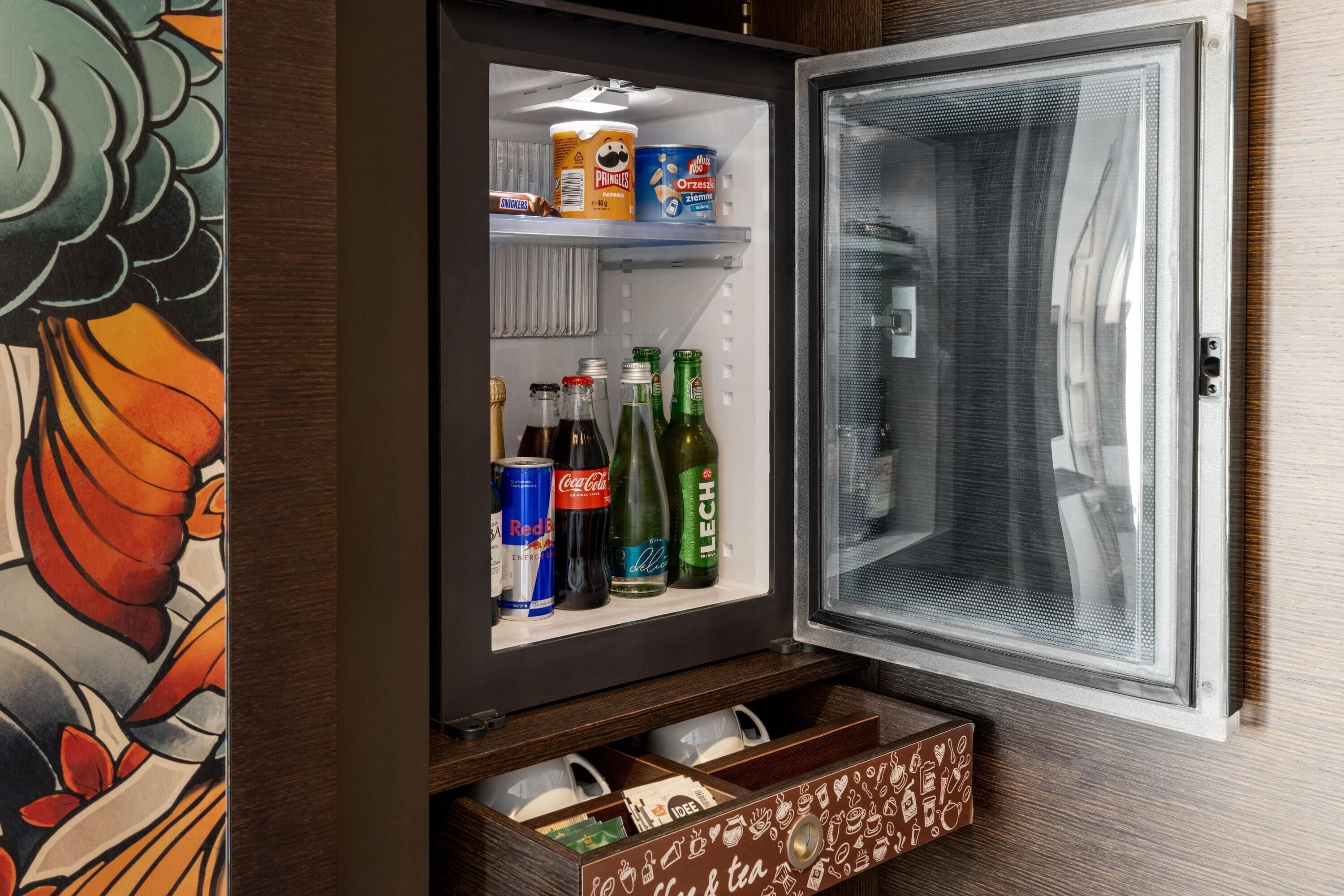 A refrigerator with a freezer compartment, containing beverages and a container of ice cream.