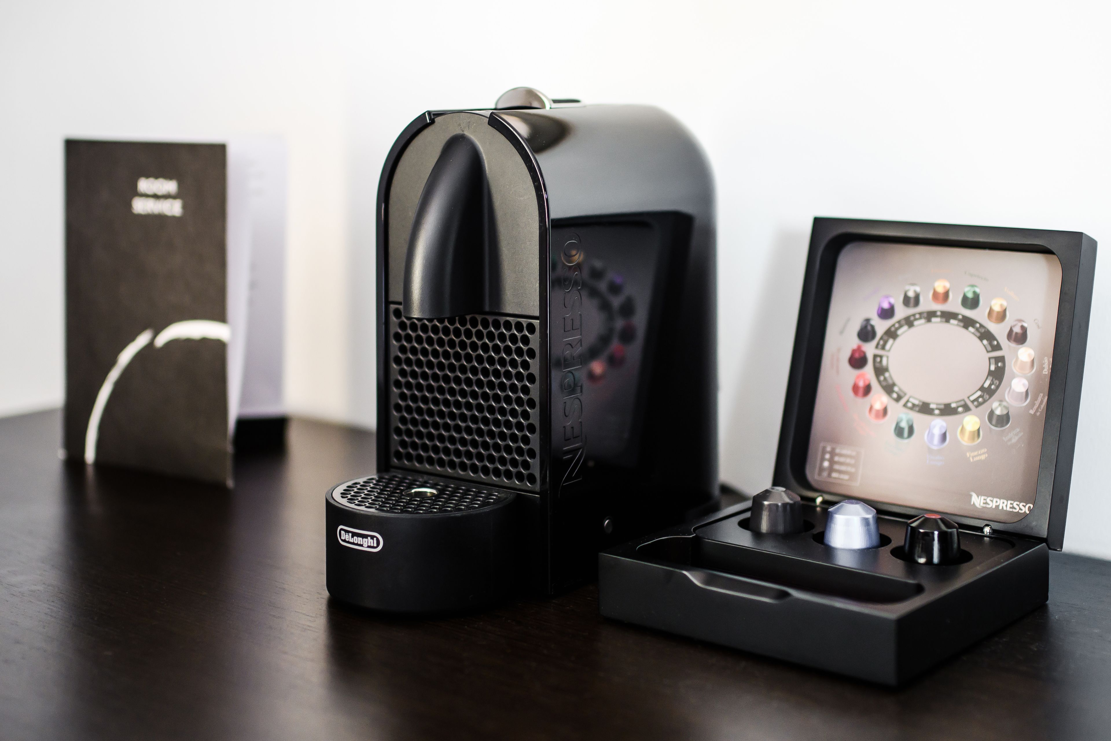 A Nespresso coffee machine and its accessories on a table.