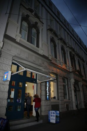 A building with a blue entrance door and a sign that reads "Hotel".