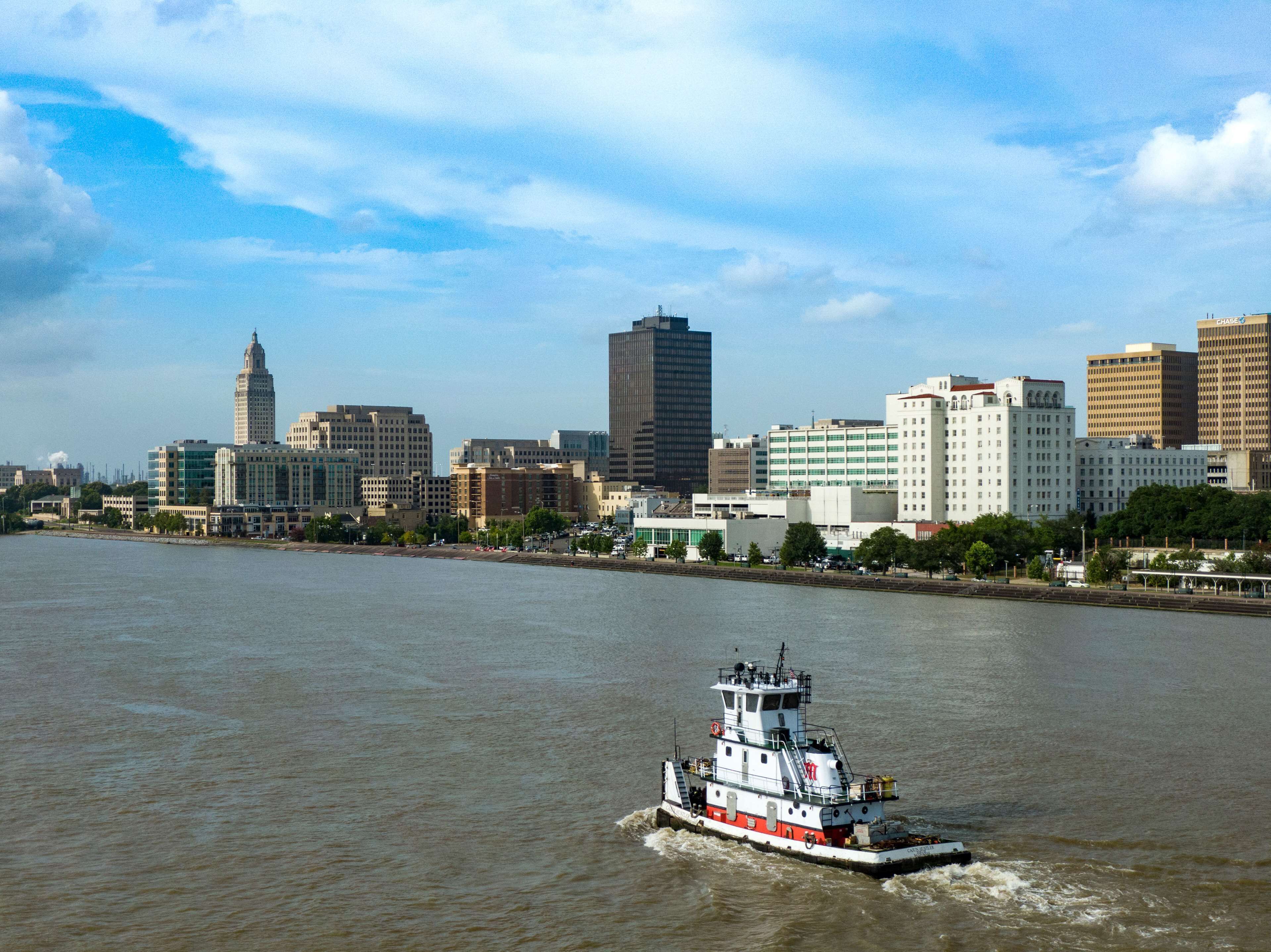 A river with a tugboat and a city skyline in the background.