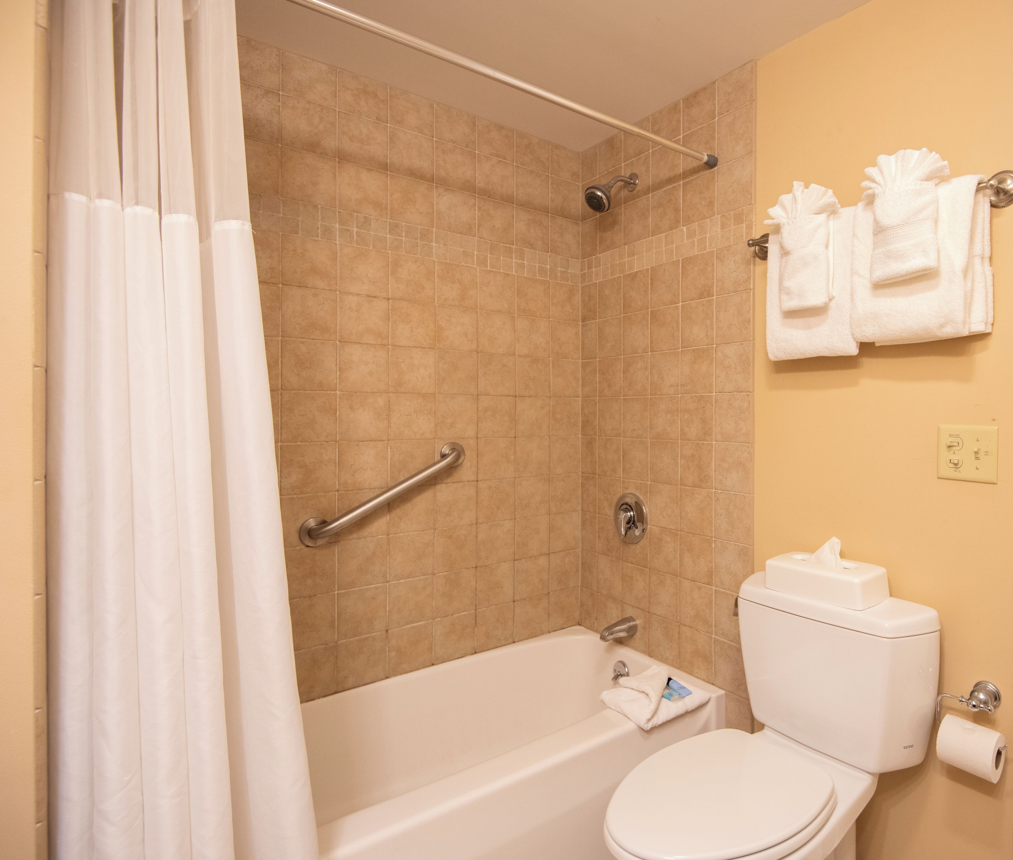 Une salle de bain équipée d’une douche, d’une baignoire, de toilettes et d’un porte-serviettes.